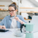 Young woman paying bills online with credit card